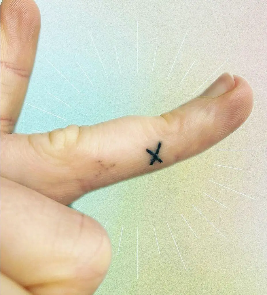 X tattoo on a finger